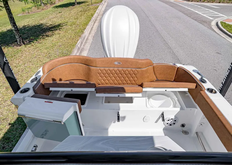 Slide: The Image of 2025 Sea Hunt Ultra 245 SE boat interior with brown seating and storage compartments. - 9