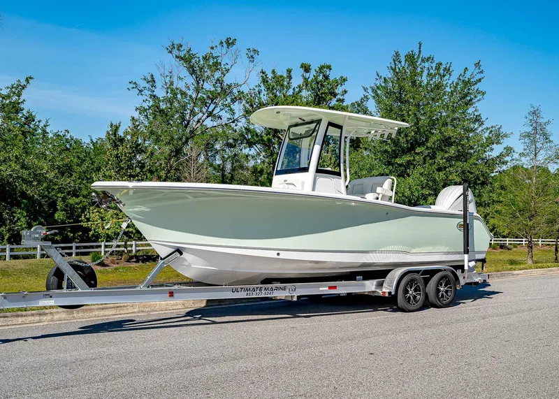 Slide: The Image of 2025 Sea Hunt Ultra 245 SE boat on trailer, parked on a sunny day. - 1