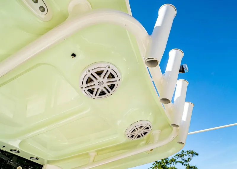 Slide: The Image of 2025 Sea Hunt Ultra 245 SE boat speakers and rod holders against clear blue sky. - 14