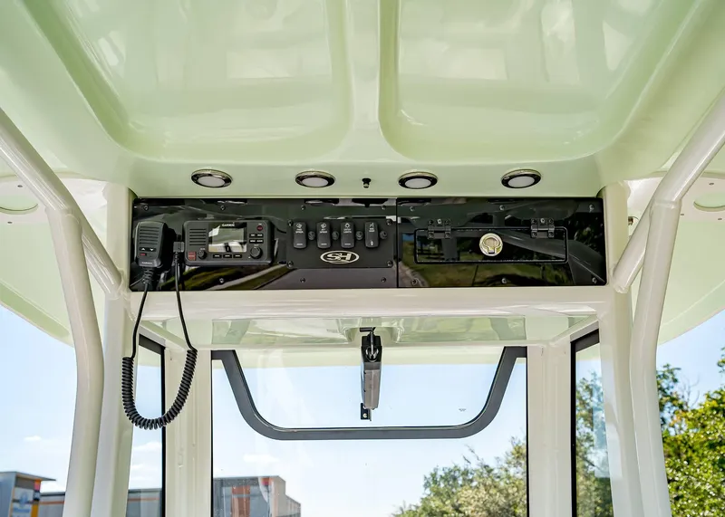 Slide: The Image of 2025 Sea Hunt Ultra 245 SE boat console with radio and control panel. - 16