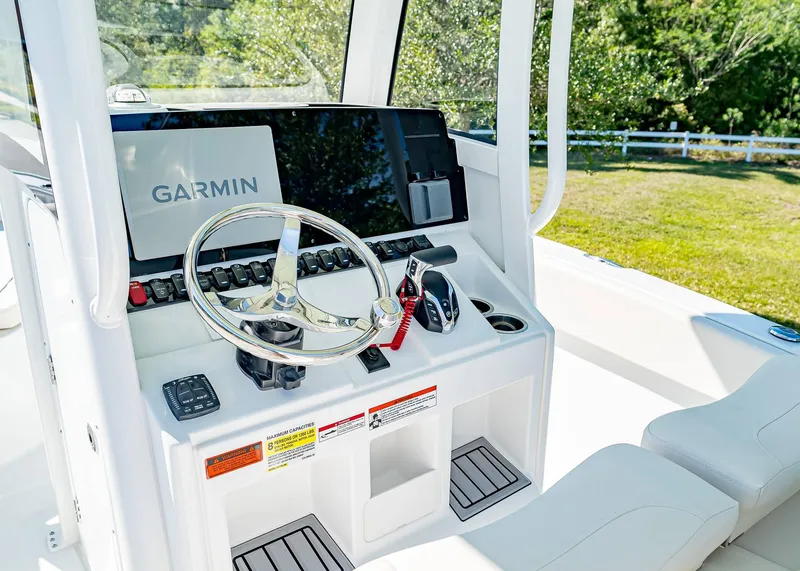 Slide: The Image of 2025 Sea Hunt Ultra 245 SE boat console with Garmin navigation system and steering wheel. - 19