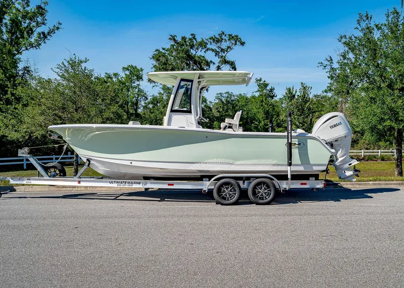 Slide: The Image of 2025 Sea Hunt Ultra 245 SE boat on trailer, parked on a sunny day. - 2
