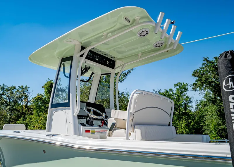Slide: The Image of 2025 Sea Hunt Ultra 245 SE boat with T-top and helm, set against a clear sky. - 4