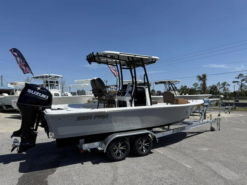 Slide: The Image of 2025 Sea Pro 230 Bay boat on trailer with Suzuki outboard motor, parked outdoors. - 3
