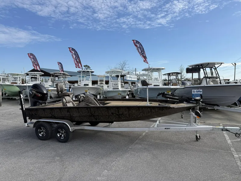 Slide: The Image of 2025 Xpress Hyper-Lift Bass Series boat on trailer at dealership, clear sky background. - 1