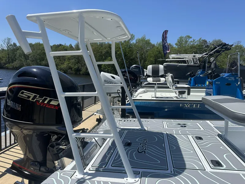 Slide: The Image of 2025 Xpress Skiff 185 boat with Yamaha VMAX engine, docked near a scenic river. - 11