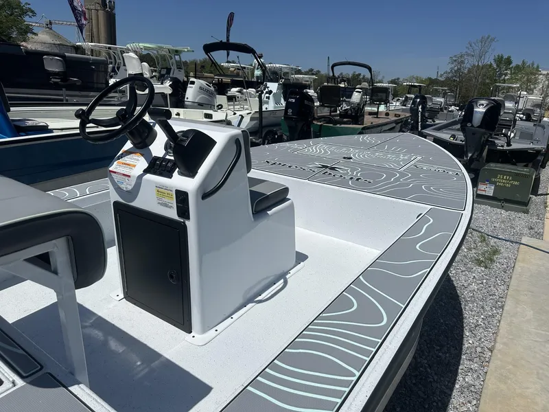 Slide: The Image of 2025 Xpress Skiff 185 boat with sleek design and modern console, displayed outdoors. - 7