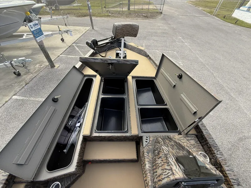 Slide: The Image of 2025 Xpress Hyper-Lift Bass Series boat with open storage compartments at a sales lot. - 5