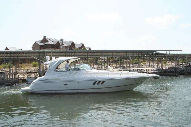 The Image of 2008 Cruisers Yachts 460 Express on water near dock and buildings. - 0
