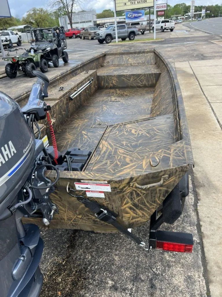 Slide: The Image of Camouflage-patterned G3 16 dk boat with Yamaha motor, parked on a dealership lot. - 19