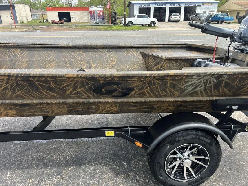 Slide: The Image of Camouflage-patterned G3 16 dk boat on trailer, 2025 model, parked near auto service shop. - 38