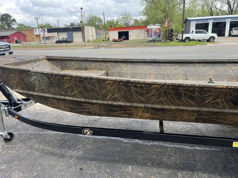 Slide: The Image of 2025 G3 16 dk boat with camouflage design on a trailer in a parking lot. - 42