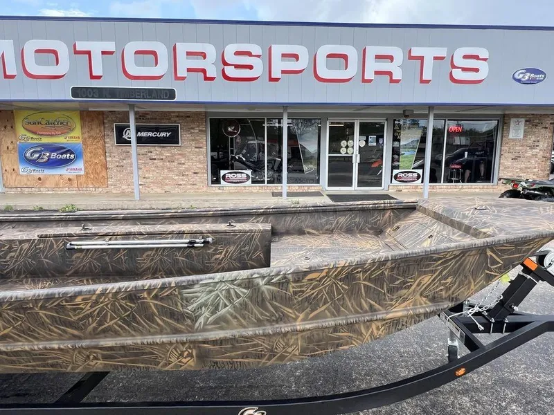 Slide: The Image of 2025 G3 16 dk boat with camouflage design outside a motorsports store. - 8