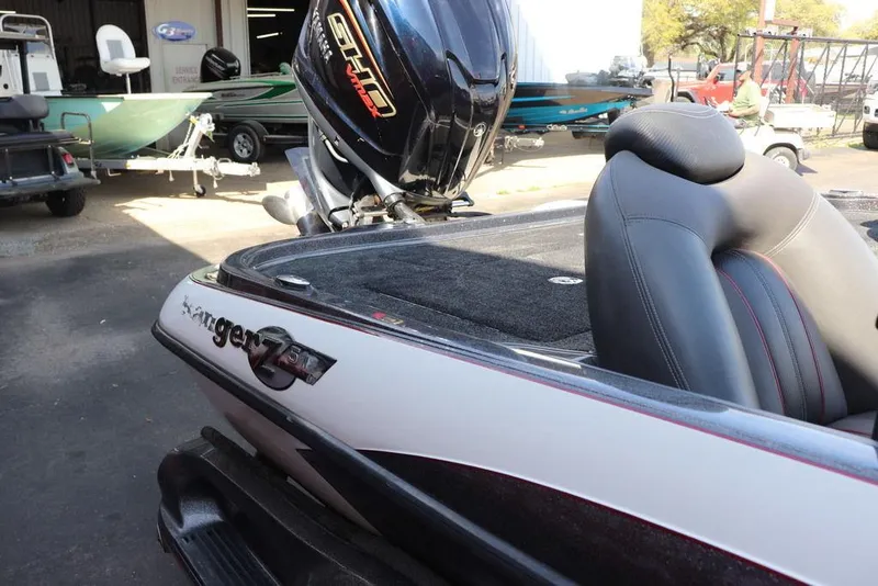 Slide: The Image of 2011 Ranger 518 boat with Yamaha engine, parked outdoors near other boats. - 14