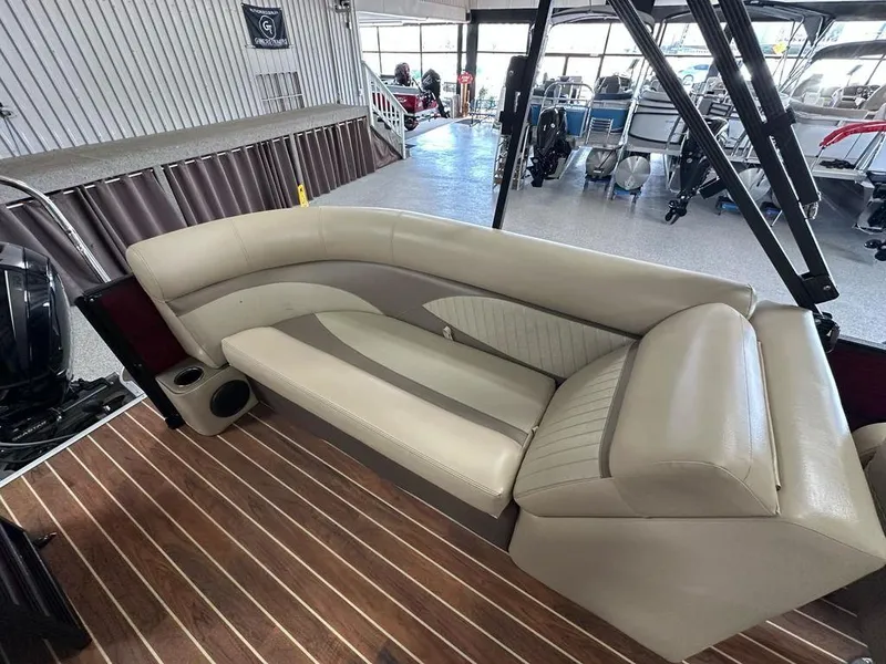Slide: The Image of 2018 Crest Classic 230 SLC boat interior with beige seating and wood flooring. - 12