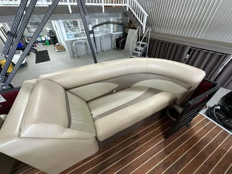Slide: The Image of 2018 Crest Classic 230 SLC boat interior with beige seating and wood flooring. - 13