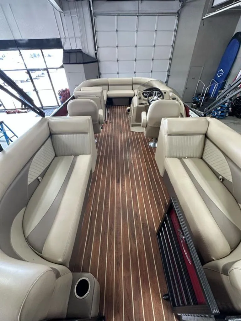 Slide: The Image of Interior of a 2018 Crest Classic 230 SLC boat with beige seating and wood flooring. - 2