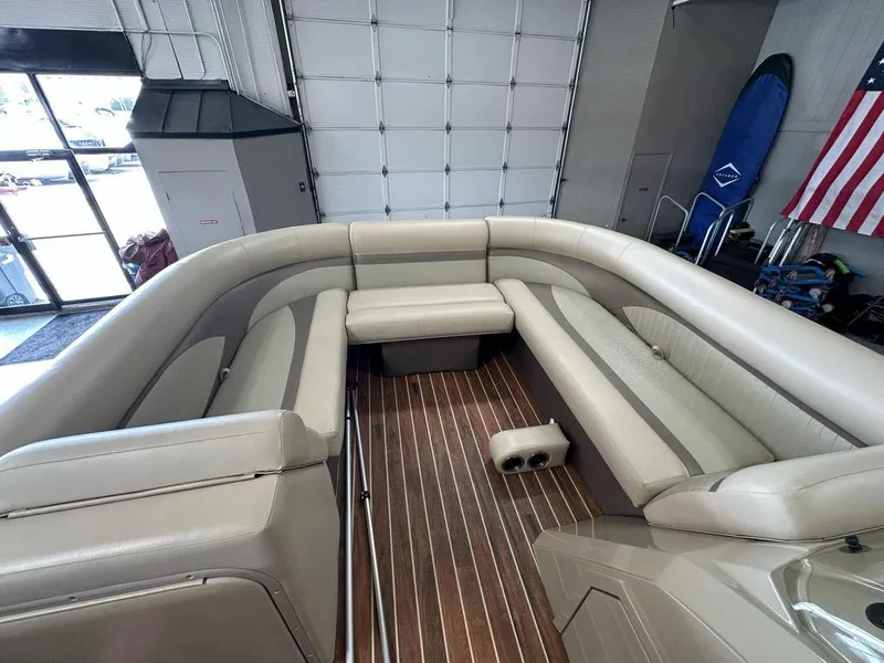 Slide: The Image of 2018 Crest Classic 230 SLC pontoon boat interior with beige seating and wood flooring. - 3