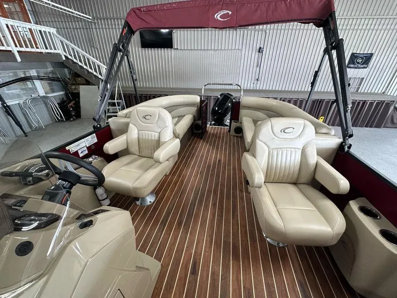 Slide: The Image of 2018 Crest Classic 230 SLC pontoon boat interior with beige seating and wood flooring. - 7