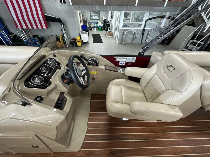 Slide: The Image of Captain's seat and helm of 2018 Crest Classic 230 SLC boat, featuring beige upholstery and wood flooring. - 8