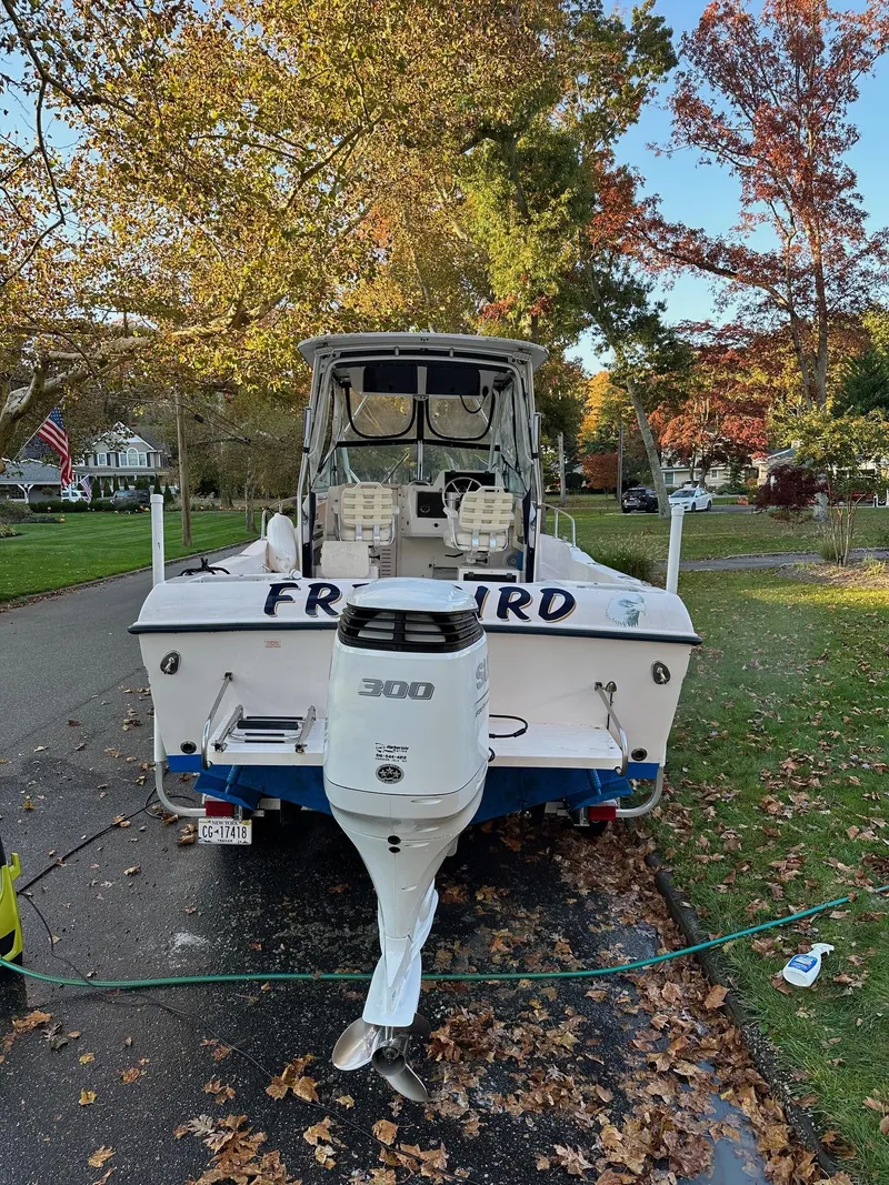 Slide: The Image of 2002 Grady-White Gulfstream 232 boat with outboard motor on a leafy street. - 5