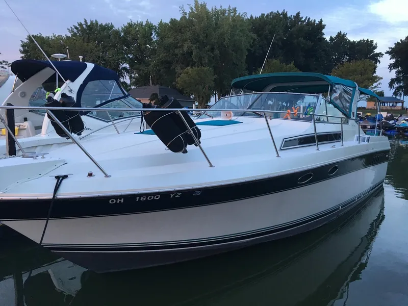 Slide: The Image of 1998 Wellcraft 3200 ST. TROPEZ boat docked in a marina, surrounded by trees. - 0