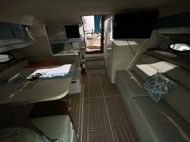 Slide: The Image of Interior of 1998 Wellcraft 3200 ST. Tropez boat with seating, table, and TV. - 12