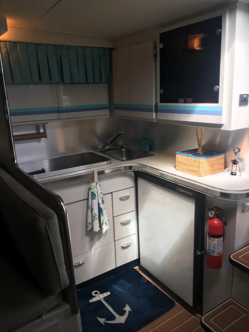 Slide: The Image of 1998 Wellcraft 3200 ST. Tropez boat kitchen with sink, cabinets, and nautical decor. - 8
