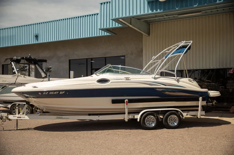 Slide: The Image of 2002 Sea Ray 240 Sundeck boat on trailer, parked outside a building. - 1