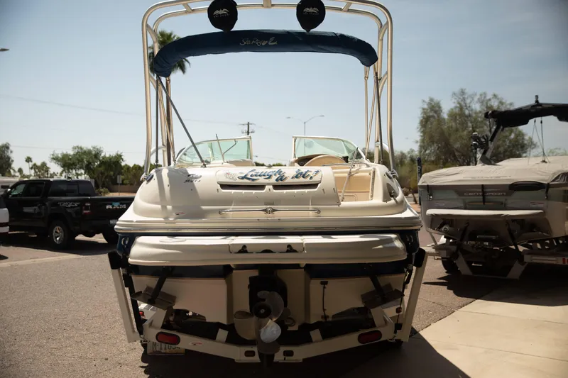 Slide: The Image of 2002 Sea Ray 240 Sundeck boat parked on a sunny day, rear view. - 3