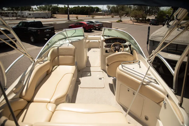 Slide: The Image of 2002 Sea Ray 240 Sundeck boat interior with beige seating and steering wheel. - 5