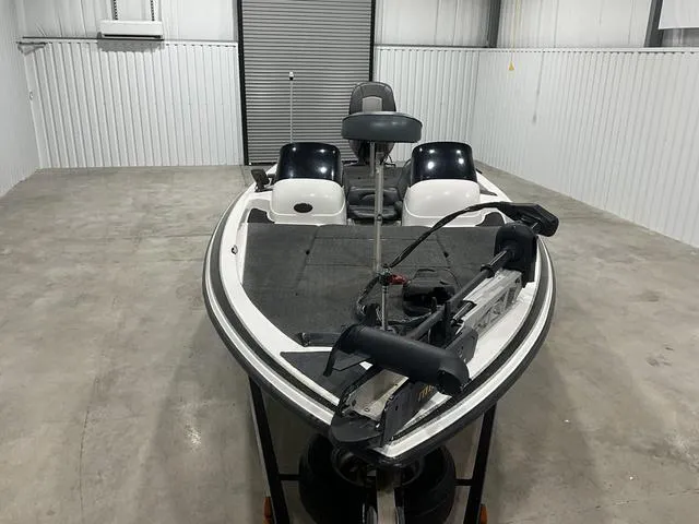 Slide: The Image of 2004 Skeeter SX190 boat in storage, featuring dual seats and a trolling motor. - 7