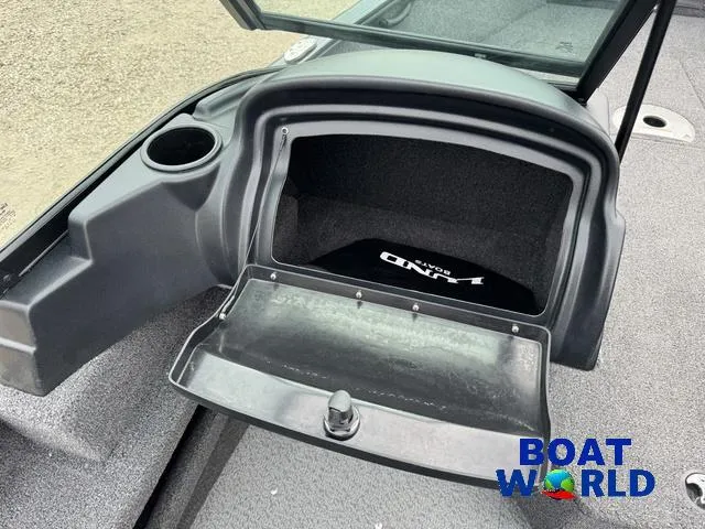 Slide: The Image of 2021 Lund 1675 Adventure Sport boat storage compartment with open lid, cup holder, and Boat World logo. - 37