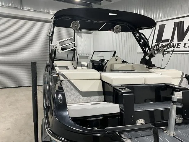 Slide: The Image of 2022 Heyday H22 boat with sleek black design and comfortable seating in a showroom. - 12