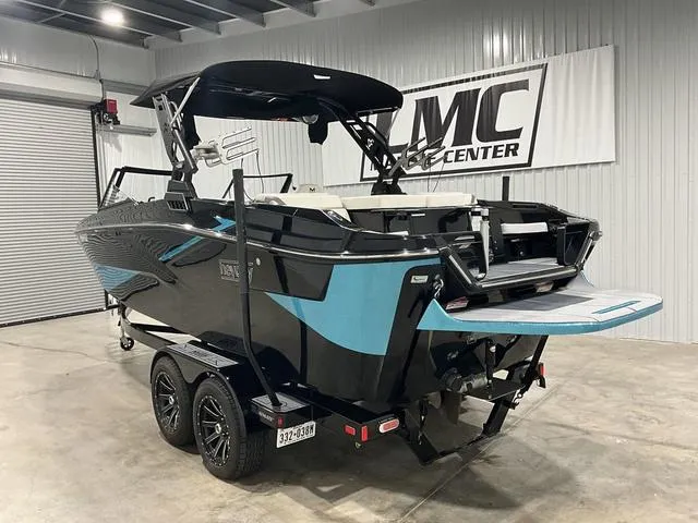 Slide: The Image of 2022 Heyday H22 boat in showroom, black and blue design, on trailer. - 4