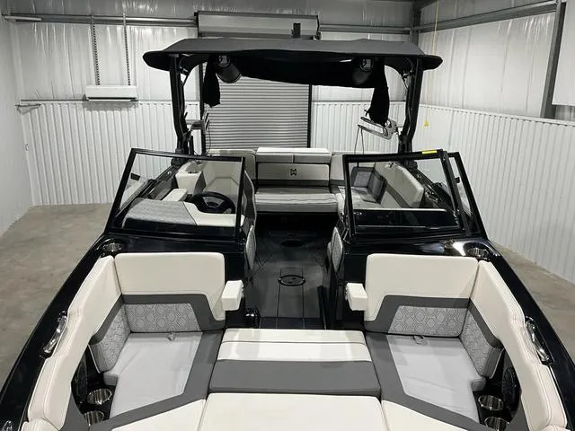 Slide: The Image of 2022 Heyday H22 boat interior with modern seating and sleek design in a storage facility. - 6