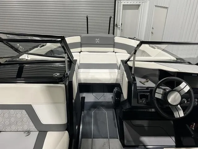 Slide: The Image of 2022 Heyday H22 boat interior with modern seating and steering wheel in a showroom. - 9