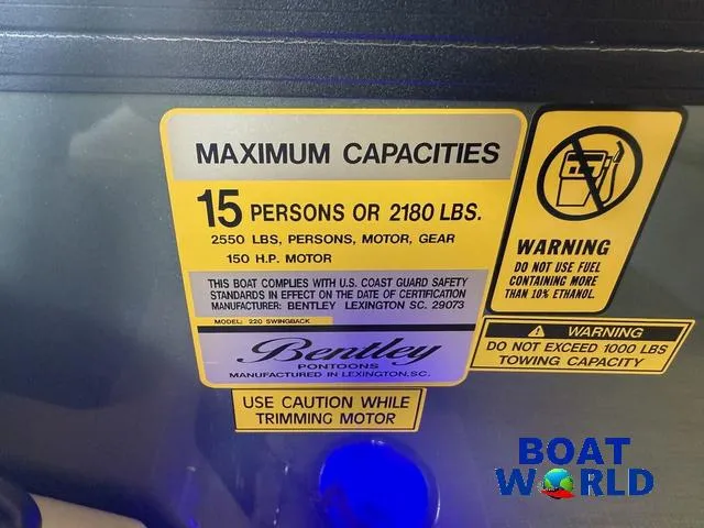 Slide: The Image of 2025 Bentley Pontoons Legacy 220 Swingback capacity label, 15 persons or 2180 lbs, safety warnings. - 16