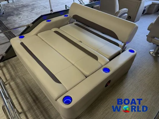 Slide: The Image of 2025 Bentley Pontoons Legacy 220 Swingback interior with beige seating and blue LED cup holders. - 18