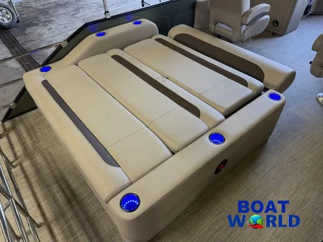 Slide: The Image of 2025 Bentley Pontoons Legacy 220 Swingback interior with beige seating and blue cup holders. - 20