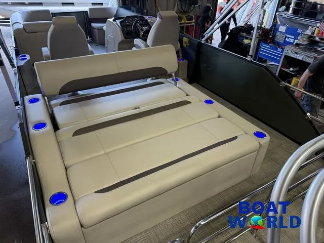 Slide: The Image of 2025 Bentley Pontoons Legacy 220 Swingback interior with beige seating and blue cup holders. - 21