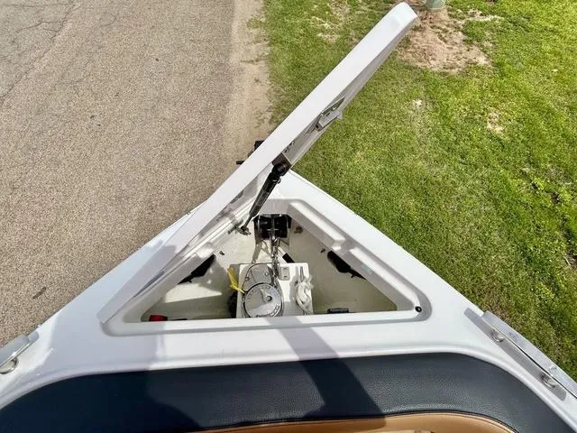 Slide: The Image of 2023 Cobalt R6 Surf boat anchor compartment open, showing storage and mechanism. - 14