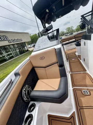 Slide: The Image of 2023 Cobalt R6 Surf boat interior with tan and black seating, near dealership. - 17