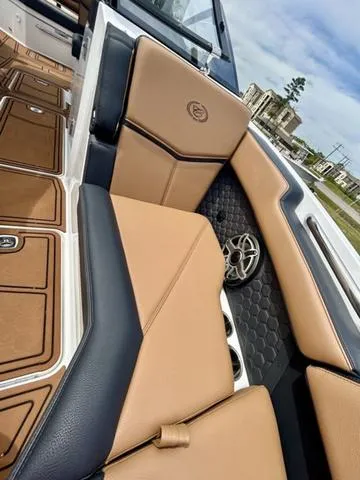 Slide: The Image of 2023 Cobalt R6 Surf boat interior with tan and black seating, hexagonal pattern, and speaker detail. - 19
