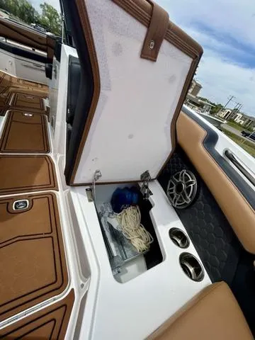 Slide: The Image of 2023 Cobalt R6 Surf boat interior with storage compartment and cup holders. - 20