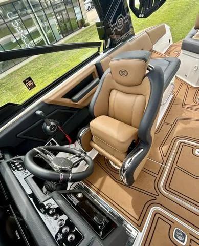 Slide: The Image of 2023 Cobalt R6 Surf boat interior with luxurious tan seating and modern steering controls. - 23