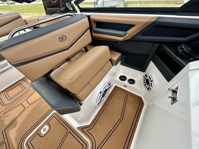 Slide: The Image of 2023 Cobalt R6 Surf boat interior with tan and black seating, speakers, and stylish design. - 25
