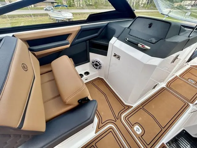 Slide: The Image of 2023 Cobalt R6 Surf boat interior with tan and black seating, modern dashboard, and speaker system. - 27