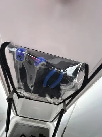 Slide: The Image of 2023 Cobalt R6 Surf boat storage compartment with tools in a clear pouch. - 31
