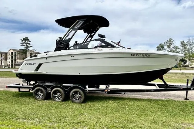 Slide: The Image of 2023 Cobalt R6 Surf boat on trailer, parked on grass, with a modern design. - 4